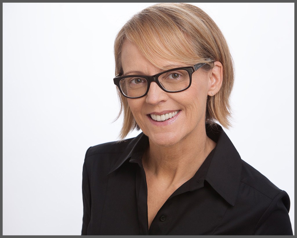 Headshot of young woman with glasses at Camera Creations Photography studio.